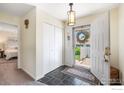 Inviting foyer with slate floors, closet, and a view into a bedroom on the left at 40 Walter Way, Broomfield, CO 80020