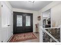 Elegant foyer with decorative double doors, an area rug, and staircase with beautiful metal work on the stair railing at 4832 Silver Sage Ct, Boulder, CO 80301