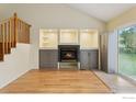 Bright living room with fireplace, built-in shelving, hardwood floors, and stairs to second level at 515 W Fir Way, Louisville, CO 80027