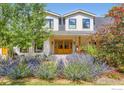 Charming home featuring a lovely front entrance with colorful flowerbeds and a beautiful set of wooden double doors at 6709 Walker Ct, Niwot, CO 80503