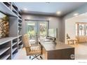 Bright office with built-in shelves, neutral walls, a cozy desk, and doors leading to the backyard at 6709 Walker Ct, Niwot, CO 80503