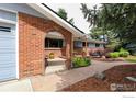 Close up of a brick archway leading to the front door, flanked by lush garden beds at 7459 Mount Meeker Rd, Longmont, CO 80503
