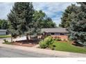 Charming single-story home with mature trees and an attractive brick exterior at 7459 Mount Meeker Rd, Longmont, CO 80503