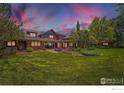 Large, landscaped backyard with patio, mature trees, and lush lawn perfect for outdoor entertaining at 8576 Niwot Meadow Farm Rd, Niwot, CO 80503