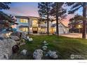 Elegant home featuring professional landscaping, a circular driveway, and a covered front porch at 90 Hawk Ln, Boulder, CO 80304
