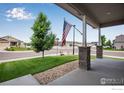 Cozy front porch with stone accents offers a charming view of the well-maintained lawn and neighborhood at 108 Wake St, Frederick, CO 80530