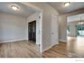 Inviting living room with wood-look floors, neutral walls, and an open doorway to other living spaces at 108 Wake St, Frederick, CO 80530
