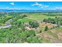 An aerial view of a lush green landscape with mountains in the distance and a winding river nearby at 10930 N 85Th St, Longmont, CO 80503