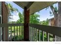 A balcony view showing the outdoor scenery, including greenery, blue skies, and partial views of neighboring houses at 12183 W Chenango Dr, Morrison, CO 80465