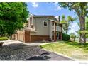 Charming multi-level home with a brick facade, gray siding, a well-maintained yard, and an attached two-car garage at 12183 W Chenango Dr, Morrison, CO 80465