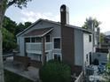 Aerial view of the multi-level property showcasing its architectural details, balcony, back deck, and surrounding yard at 12183 W Chenango Dr, Morrison, CO 80465