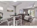 Living room with modern furnishings, gray tones, wood floors and sliding glass doors to deck at 12183 W Chenango Dr, Morrison, CO 80465