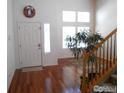 Bright foyer with hardwood floors, a decorative wreath, and a view of the staircase at 12609 Jersey W Cir, Thornton, CO 80602