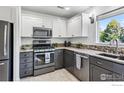 Modern kitchen featuring stainless steel appliances, granite countertops, and white and gray cabinetry at 1993 S Fork Dr, Lafayette, CO 80026