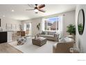 Open-concept living room featuring a ceiling fan, a large window and patio access at 2742 Cooperland Blvd, Berthoud, CO 80513