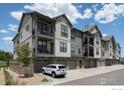 Modern condo building features balconies, stone accents, and attached garages for convenient parking at 285 High Point Dr # H-104, Longmont, CO 80504