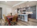 Open kitchen with a large kitchen island, modern appliances, pendant lighting, and an adjacent dining area at 285 High Point Dr # H-104, Longmont, CO 80504