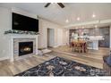 Spacious living room with a fireplace, kitchen view, ceiling fan and plank flooring at 285 High Point Dr # H-104, Longmont, CO 80504