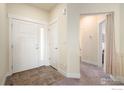 Inviting foyer featuring tile flooring at entrance transitioning to carpet and white trim at 338 Lemonade Dr, Berthoud, CO 80513