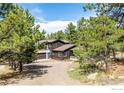 Beautiful exterior view of a modern home nestled among mature trees in a serene setting at 37 Wagner Cir, Boulder, CO 80304