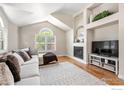 Bright living room with vaulted ceilings, hardwood floors, fireplace, and built-in shelving at 388 Fairfield Ln, Louisville, CO 80027