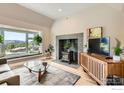 Inviting living room features a stylish fireplace, large windows with scenic views, and hardwood floors at 4815 Sugarloaf Rd, Boulder, CO 80302