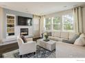 Inviting living room with a fireplace, built-in shelving, and large windows at 5451 W 73Rd Ave, Westminster, CO 80003