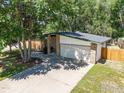 Home exterior showcases a brick facade, a two-car garage, mature trees, and a quaint walkway leading to the entrance at 603 Hilltop St, Longmont, CO 80504