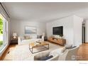 Bright living room with a large window, wood floors, a neutral color palette, and comfortable furnishings at 603 Hilltop St, Longmont, CO 80504