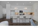 Bright kitchen with white cabinets, center island with seating, and stainless steel appliances at 729 Kubat Ln # A, Longmont, CO 80503