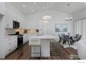 Modern kitchen with a large central island, stainless steel appliances, and hardwood floors at 729 Kubat Ln # A, Longmont, CO 80503