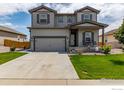 Attractive two-story home showcasing a well-manicured lawn, two-car garage, covered porch, and neutral exterior paint at 7414 Blue River Ave, Frederick, CO 80530