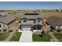Lovely two-story home with solar panels, a two-car garage, and a beautifully landscaped front yard with green lawn at 7414 Blue River Ave, Frederick, CO 80530