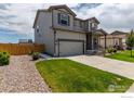 Side view of two-story home showcasing the neutral siding, front yard, and fenced-in neighboring property at 7414 Blue River Ave, Frederick, CO 80530