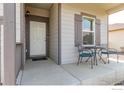 Inviting porch with seating area, showcasing the home's entry with a white door and adjacent window at 7414 Blue River Ave, Frederick, CO 80530
