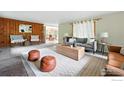 Bright living room with wood paneled wall, fireplace, comfortable seating, and view into adjacent dining area at 775 Pleasant St, Boulder, CO 80302