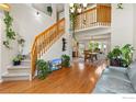 Open foyer with hardwood floors, staircase, and view of the dining area at 1026 Red Oak Dr, Longmont, CO 80504