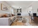 Comfortable living room with neutral tones, fireplace, and open dining area at 10430 Owens Cir, Broomfield, CO 80021