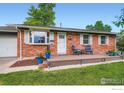 Inviting brick home with a cozy front porch featuring outdoor seating at 1085 Jade St, Broomfield, CO 80020