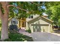 Two-story home with attached garage, lush landscaping, and charming exterior at 1117 Barberry Ct, Boulder, CO 80305