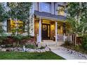 Inviting front entrance with decorative wreath, brick accents and lovely landscaping at 1405 Clover Creek Dr, Longmont, CO 80503