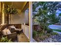 Cozy covered front porch with comfortable seating and hanging plant at 1405 Clover Creek Dr, Longmont, CO 80503