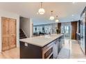 Open kitchen features a large island with sink and stainless steel dishwasher at 1405 Clover Creek Dr, Longmont, CO 80503