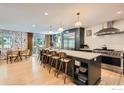 Open-concept kitchen features an expansive island, modern appliances, and an adjacent dining area at 1405 Clover Creek Dr, Longmont, CO 80503