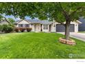 Beautiful house with landscaped lawn, mature tree, and attached two car garage at 142 S Fillmore Ave, Louisville, CO 80027