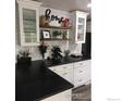 Well decorated kitchen featuring white cabinets, subway tile backsplash, and dark countertops with floating shelves at 142 S Fillmore Ave, Louisville, CO 80027