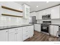 Bright kitchen features white cabinets, stainless appliances, and modern finishes at 142 S Fillmore Ave, Louisville, CO 80027