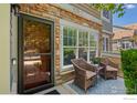 Cozy patio with woven chairs and a view through the screen door, framed by brick and greenery at 14300 Waterside Ln # E3, Broomfield, CO 80023