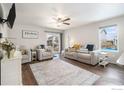 Spacious living room featuring a ceiling fan, plush seating, and a sliding glass door to the backyard at 2065 Wildwood St, Lochbuie, CO 80603