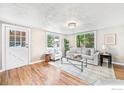 Bright living room with hardwood floors, large windows, and stylish furniture at 222 Vivian St, Longmont, CO 80501